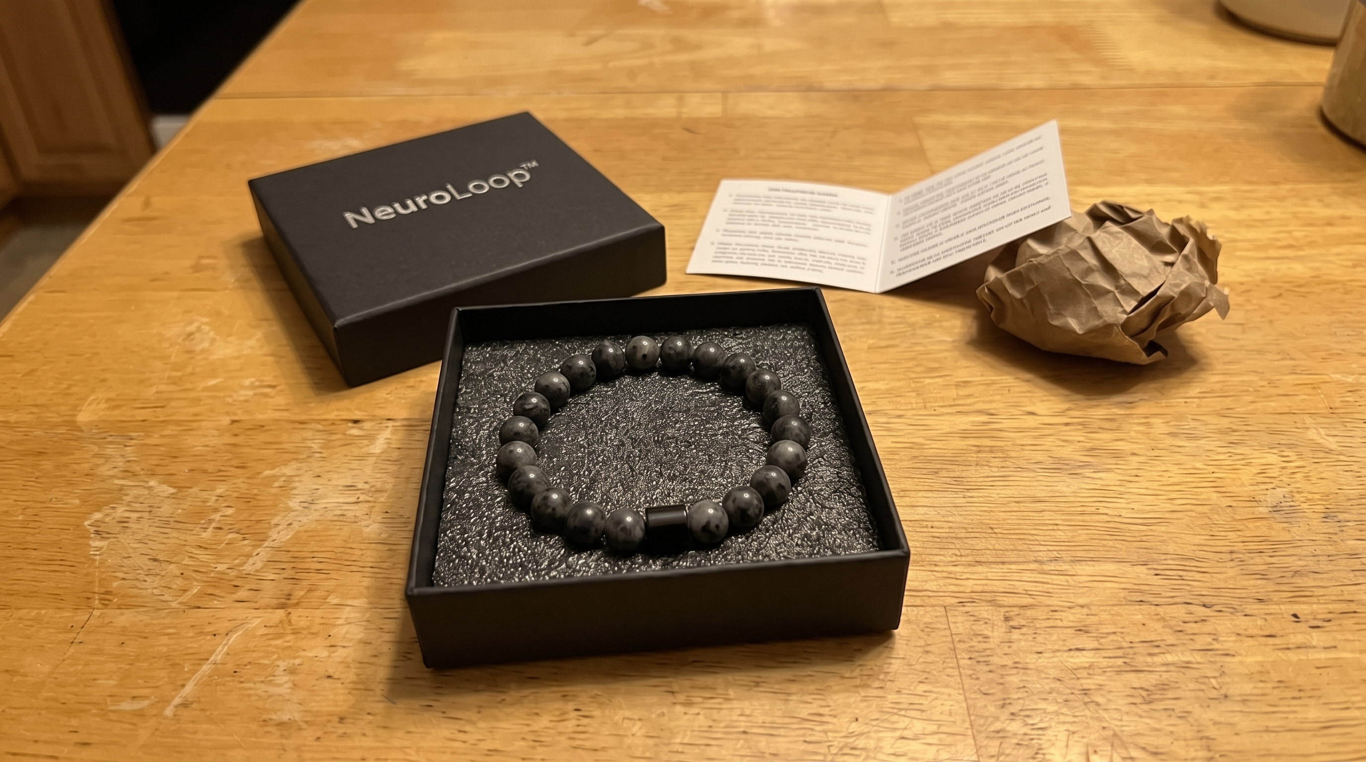 Otwarte pudełko NeuroLoop™ z bransoletką na stole
